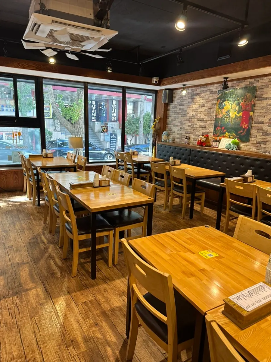 Interior with wood-tone tables and brick decor