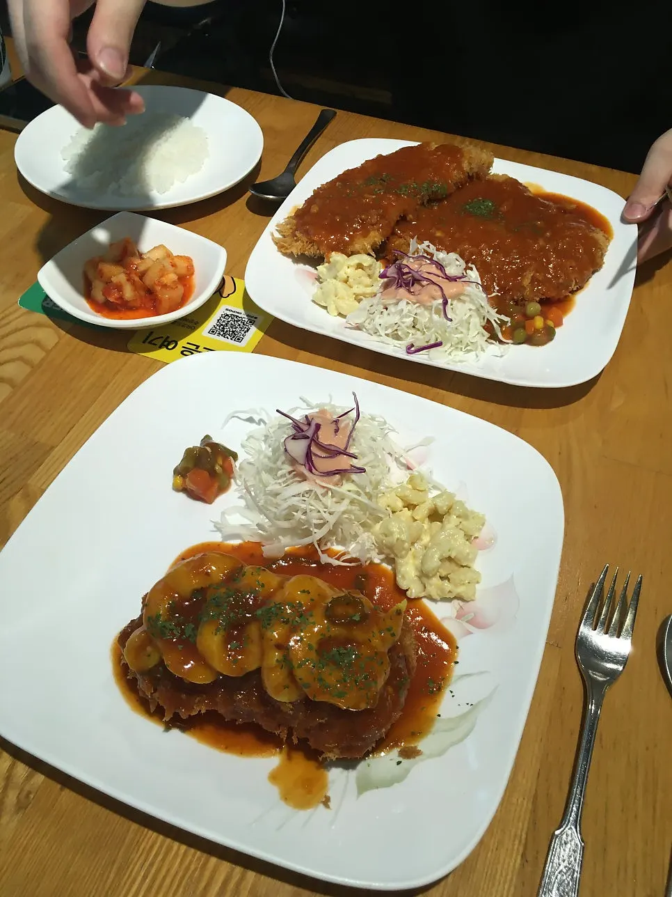 A full table setting with two plates of pork cutlet