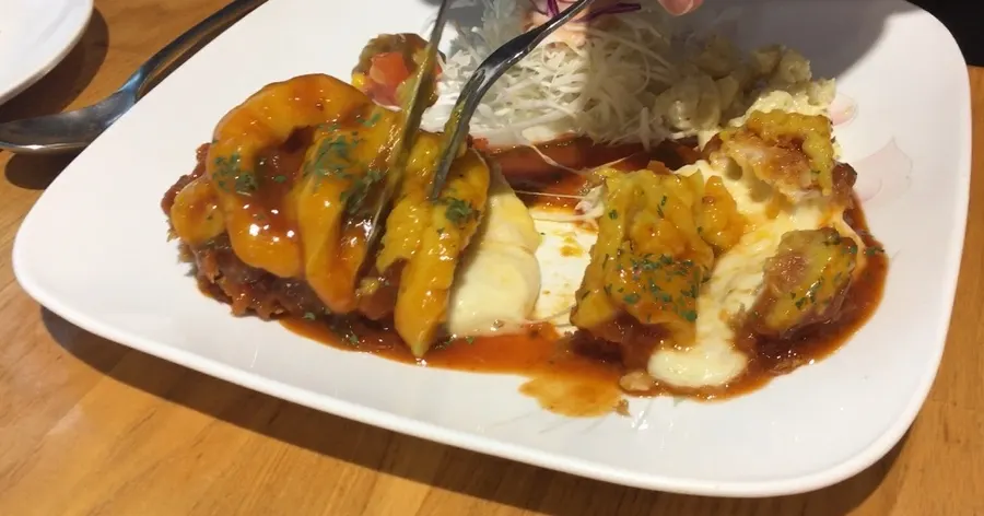 Cheese oozing from a cut cheese cutlet