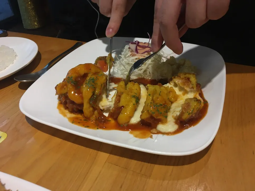 A piece of pork cutlet with stretchy melted cheese