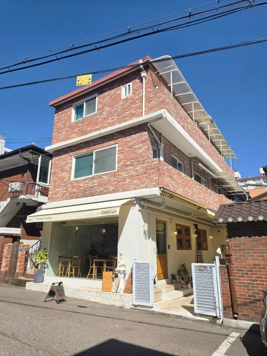 Exterior of Dalgeuraem on the ground floor of a red brick building in a Gyesan-dong alley