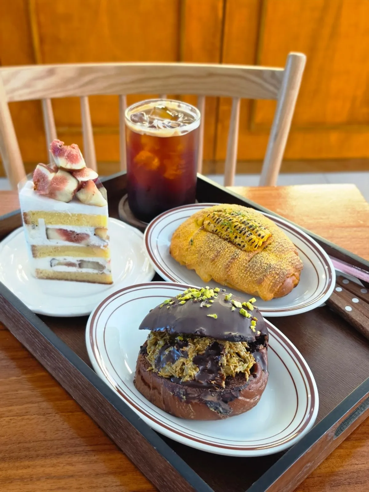 Tray with Dubai chocolate salt bread, fig yogurt cake and iced Americano