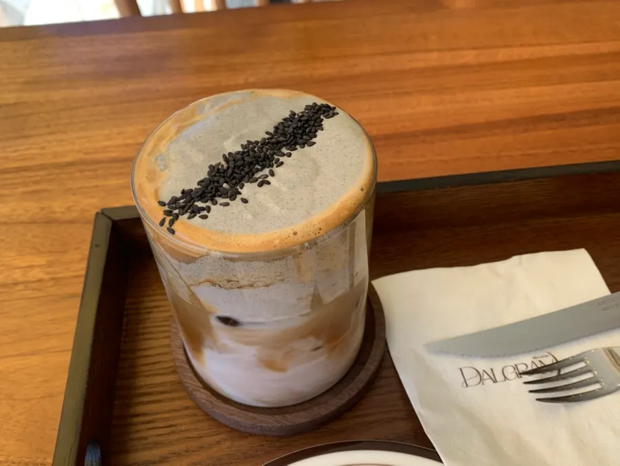 Table setting with black sesame latte, egg tart, and corn salt bread