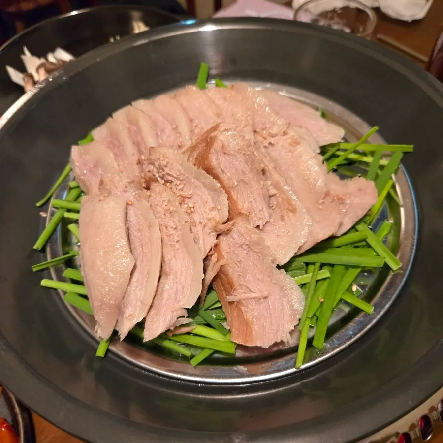 Pork jowl suyuk for two boiled in barley broth, table setup at Dambaek Jujeom