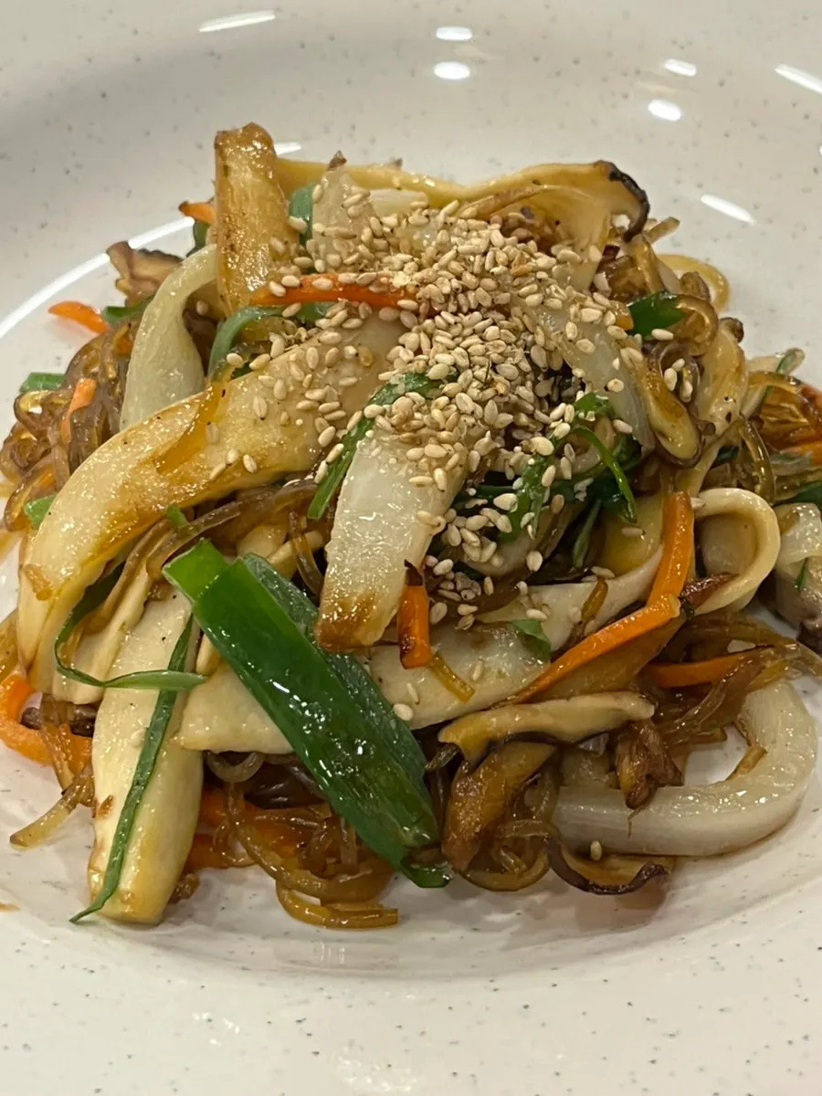 A bite of japchae with soft glass noodles