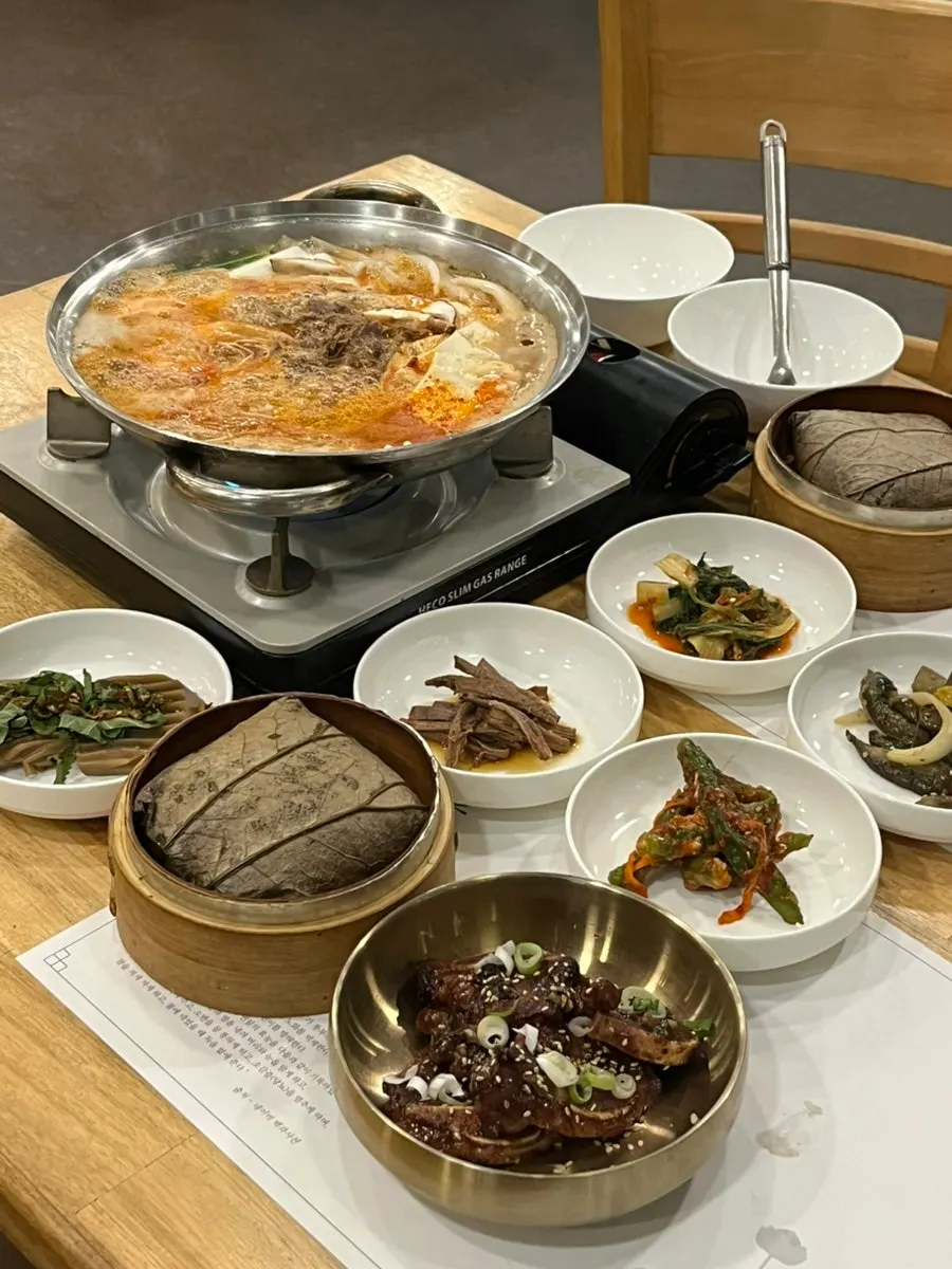 Main meal spread with lotus leaf rice, side dishes, tofu hot pot, and LA galbi