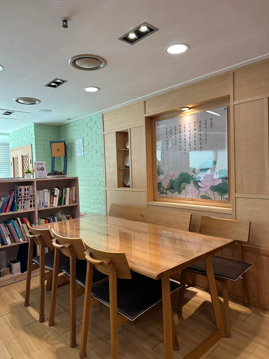 Interior of Damil with wood tones and floor-to-ceiling windows