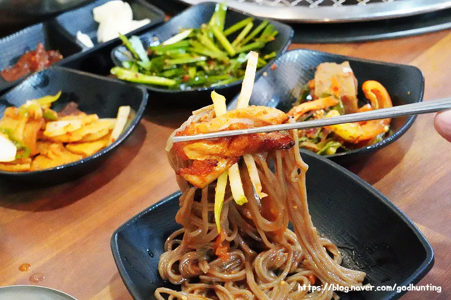 비빔막국수에 닭갈비 한 점을 곁들인 모습