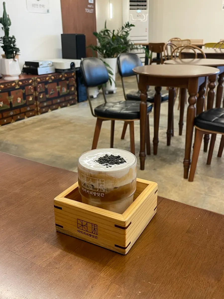 MIMI cream latte served on a grain-measuring box tray