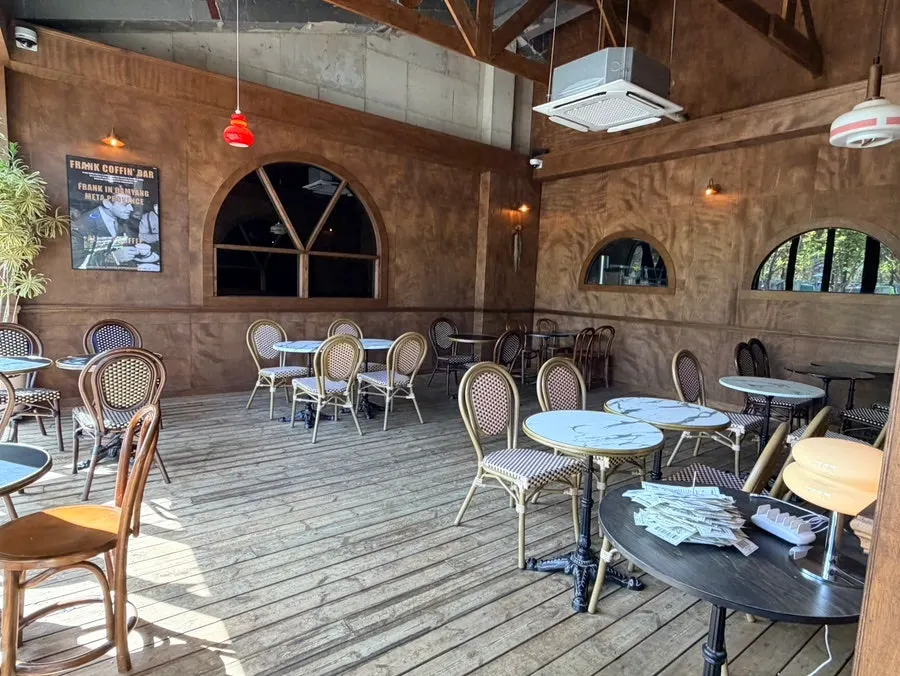 Spacious seating area toward the back of the store with wide table spacing
