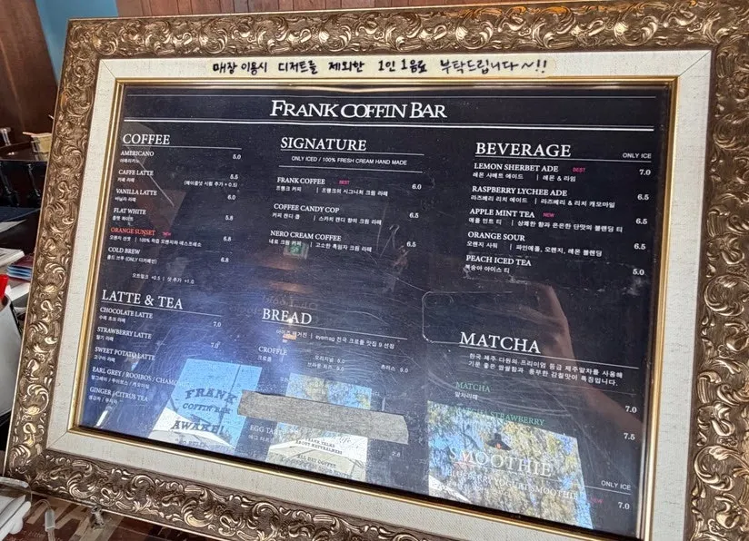 Frank Coffin Bar menu board listing coffee, lattes, and signature drinks
