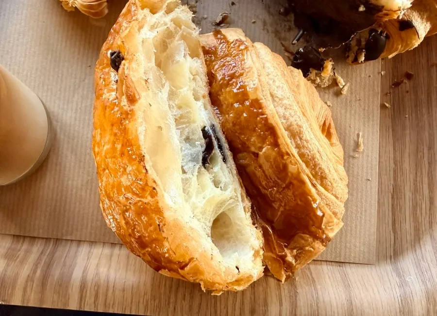 Egg tart and croissant served alongside coffee