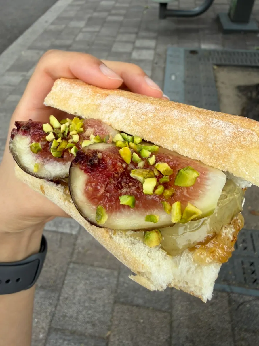 Eating the fig pistachio baguette on the bench