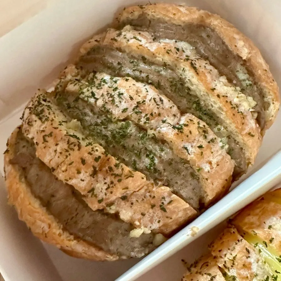 Crispy-outside-soft-inside baguette garlic bread topped with garlic flakes