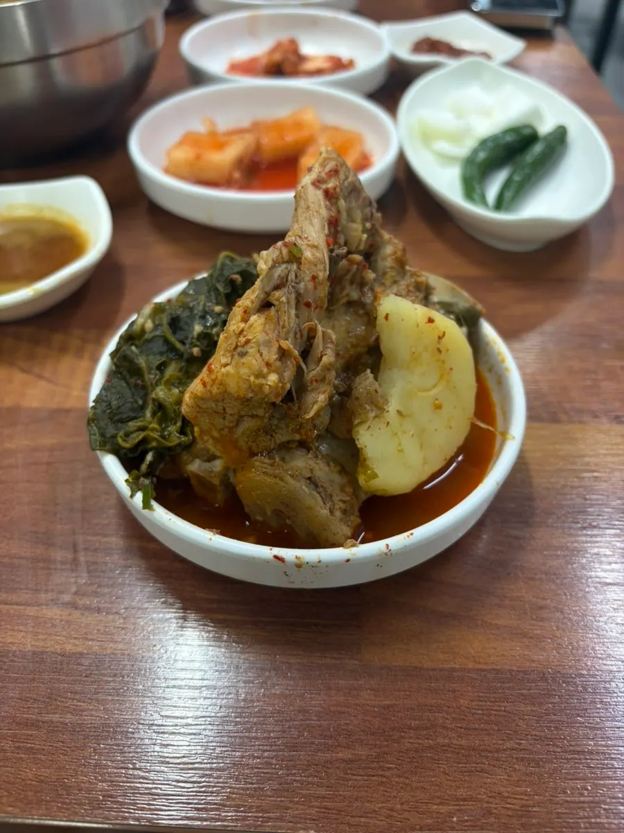 Spicy gamjatang broth topped with perilla leaves