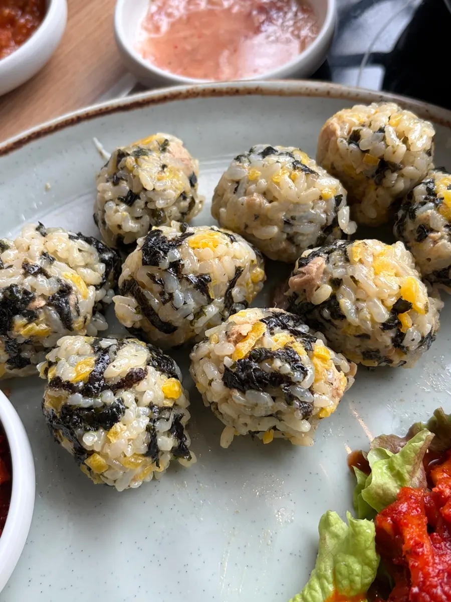 A bite of bossam topped with the rice ball