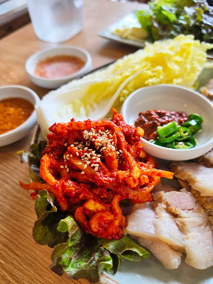 Bossam kimchi piled on top of a piece of bossam
