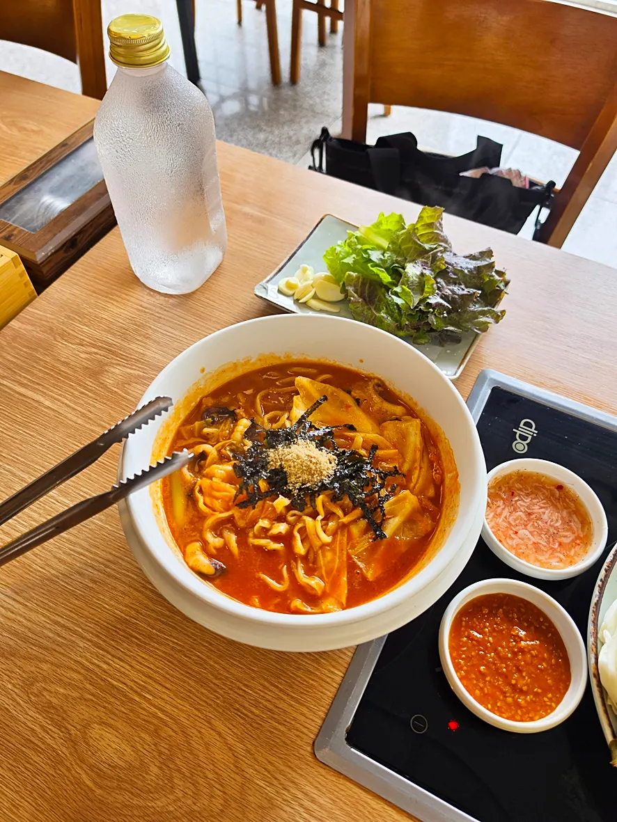 Kalguksu noodles lifted out of the spicy broth