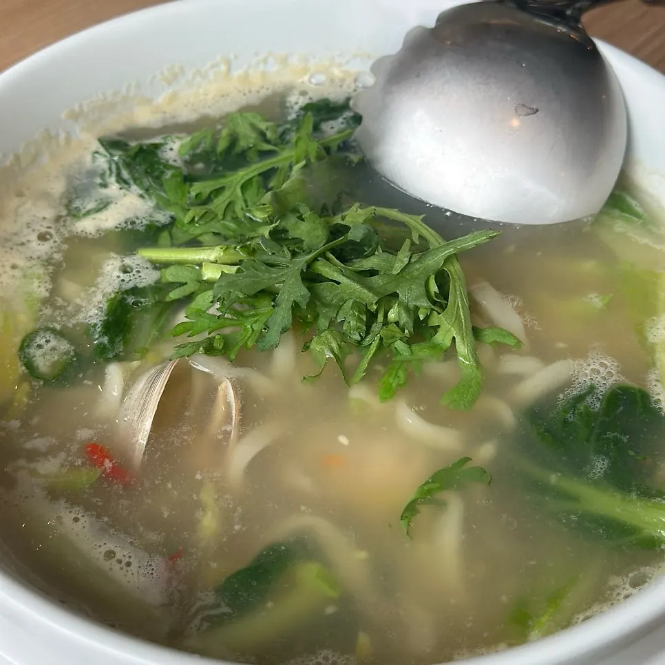 Bowl of clam noodle soup packed with clams