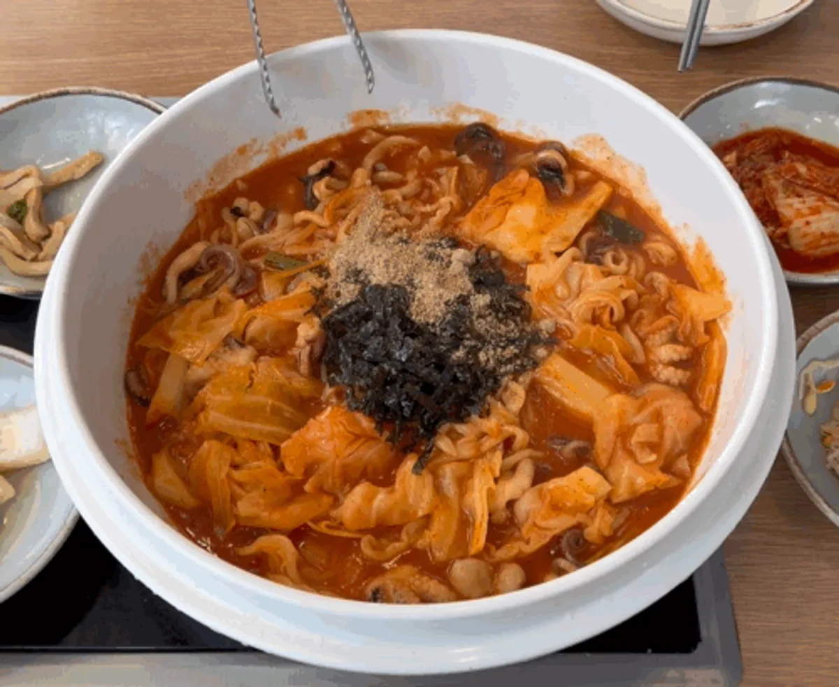 Spicy kalguksu for two topped with octopus