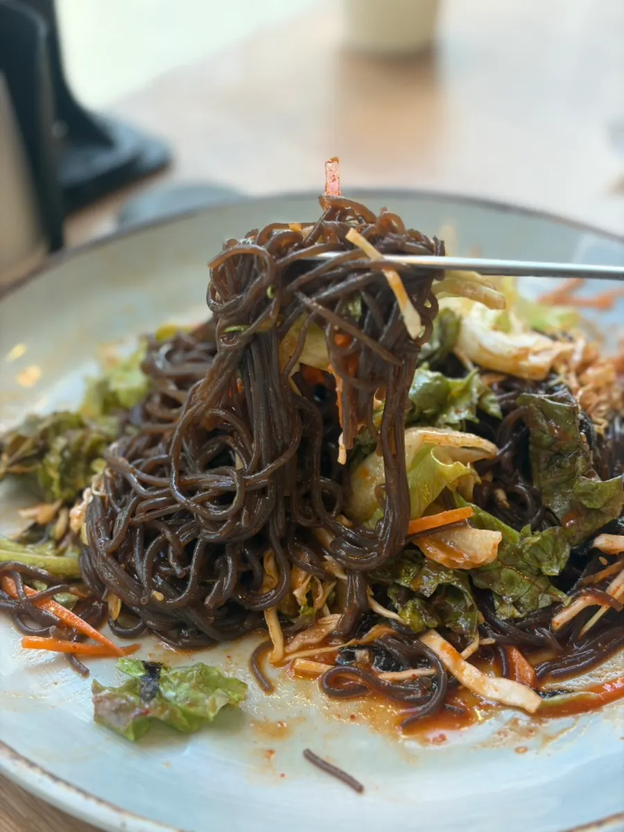 Close-up of jaengban makguksu tossed in sauce
