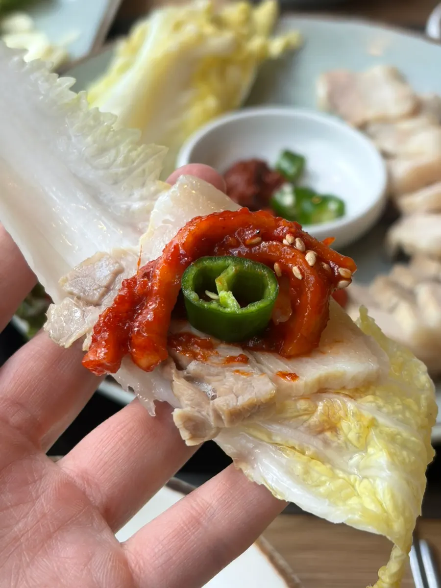Bossam wrap topped with bossam kimchi