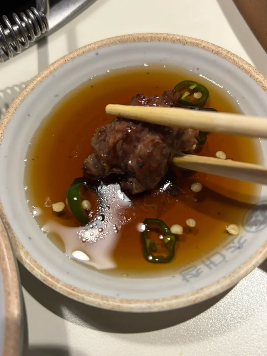 A clear-style doenjang jjigae with a bowl of rice
