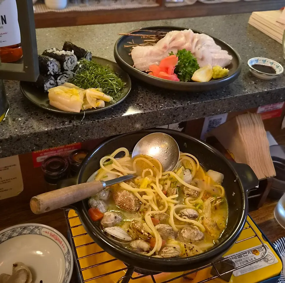 Full counter spread of clam sake-steam and flounder salt sushi