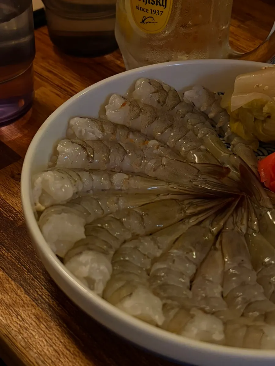 A large plate of raw shrimp sashimi