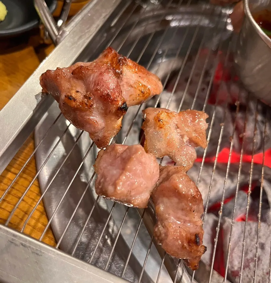 A piece of kkodeulsal picked up with chopsticks