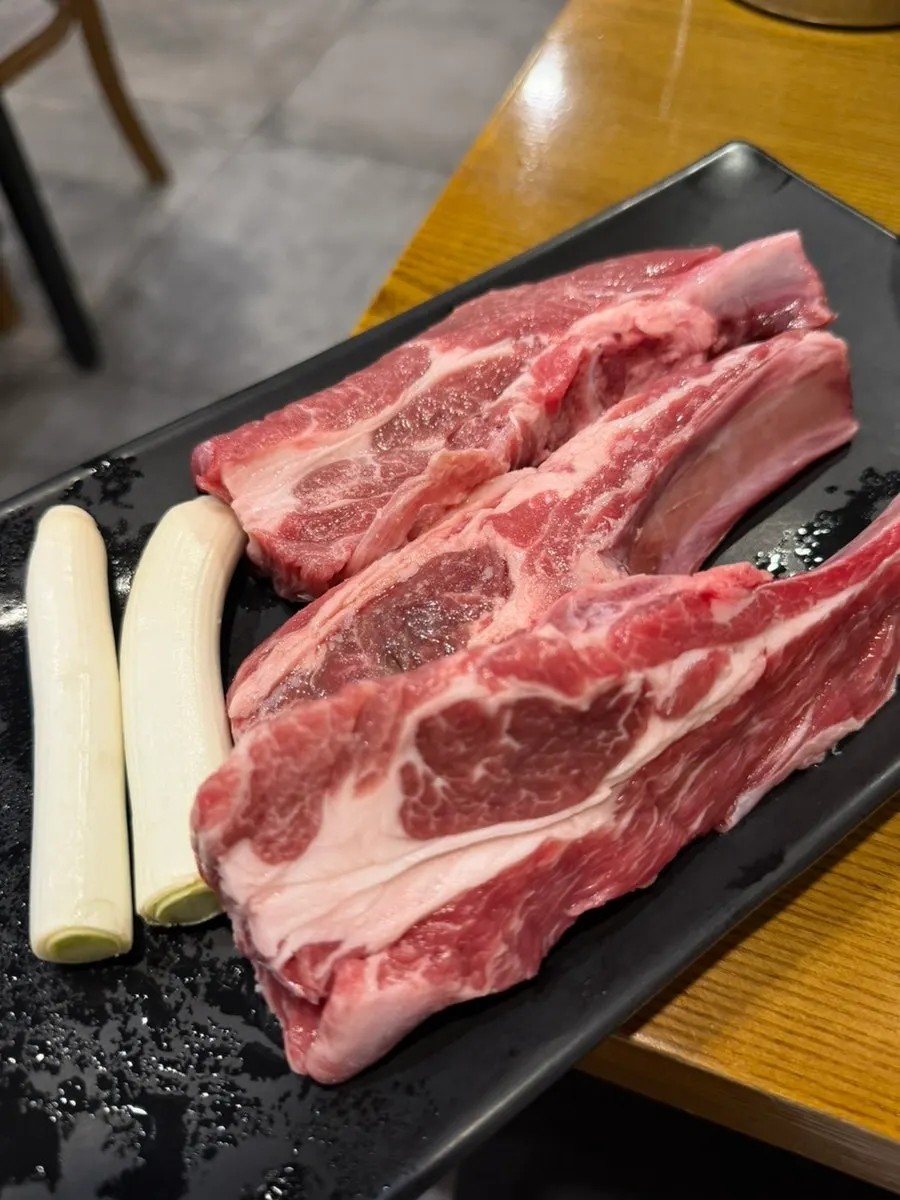 Two servings of thick raw lamb ribs