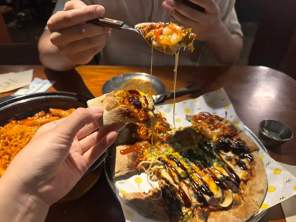 Meja dengan pizza half-and-half dan cheese ratbokki