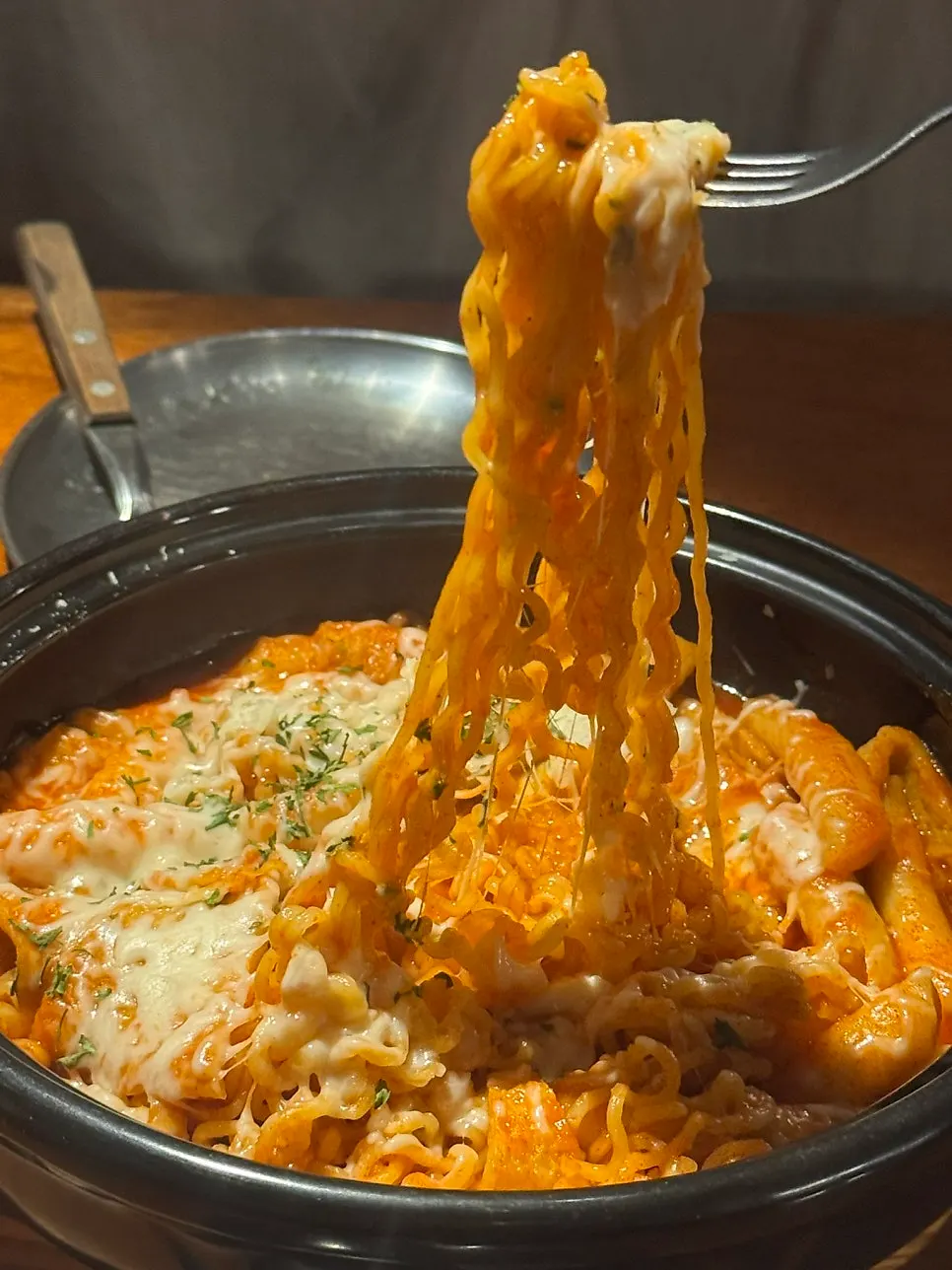 Hidangan pizza, ratbokki dan bir bersama di meja