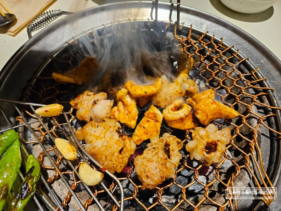 A fully grilled piece of daechang being picked up