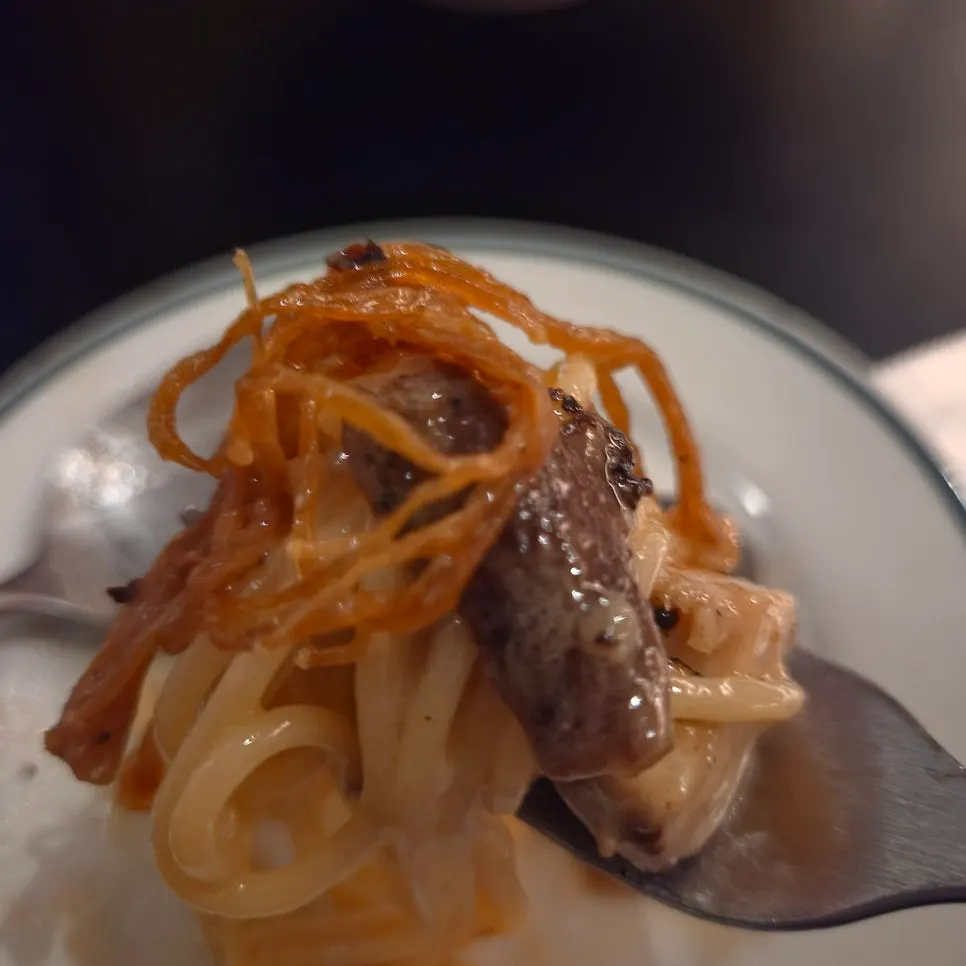 Close-up of mushroom cream pasta topped with dried enoki
