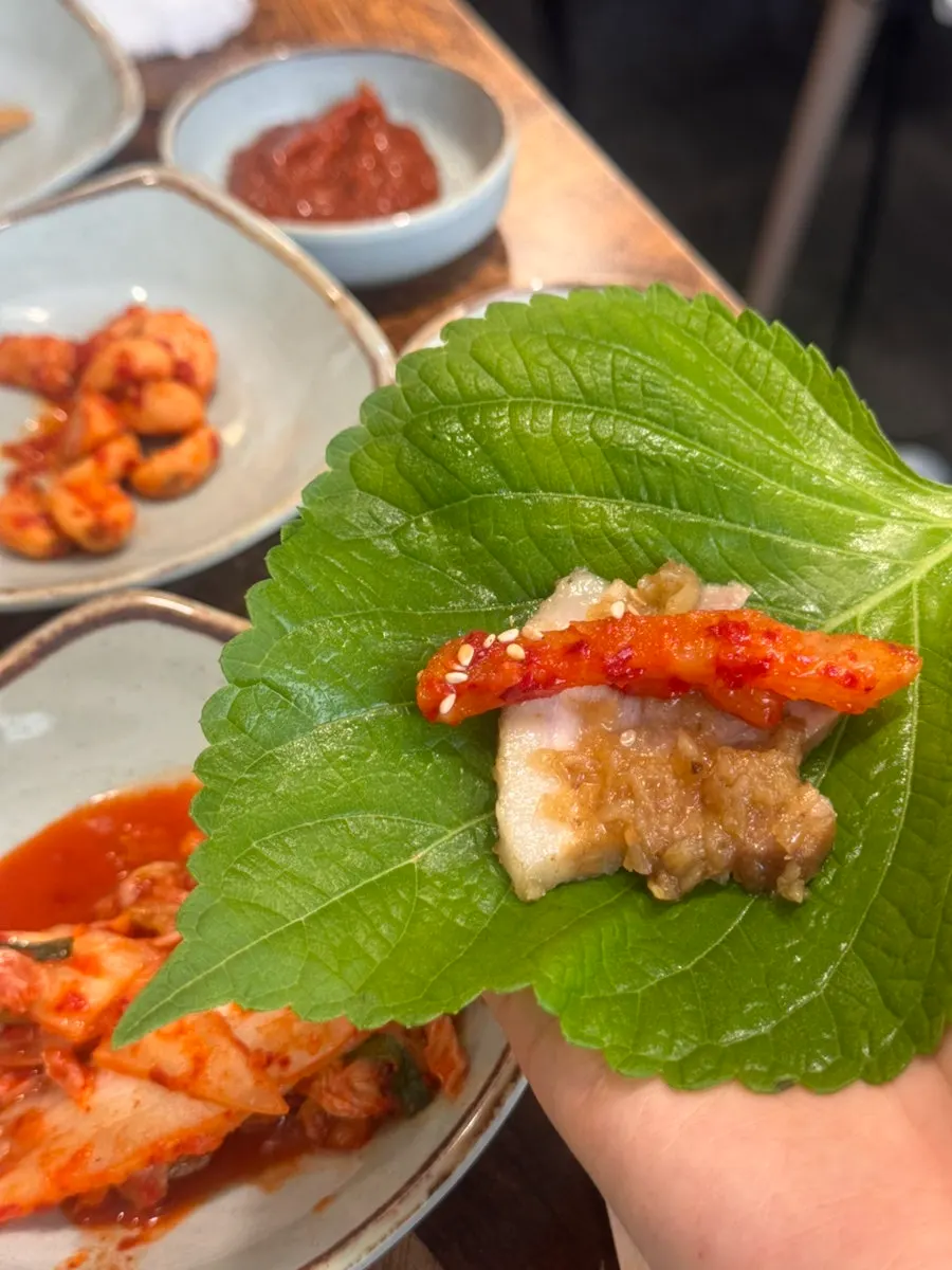 A piece of black garlic suyuk paired with kimchi