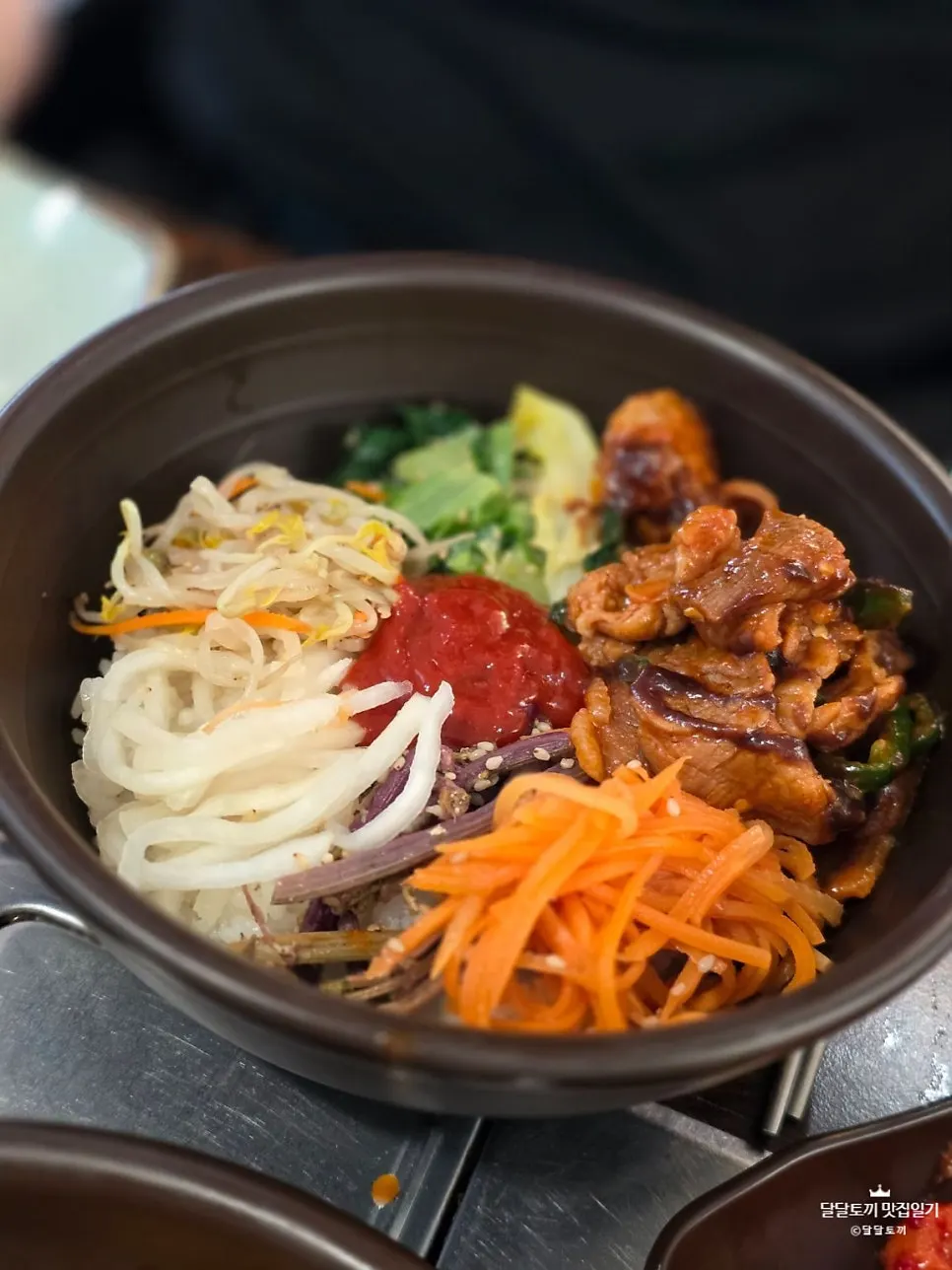 Bowl of barley bibimbap topped with namul and jeyuk