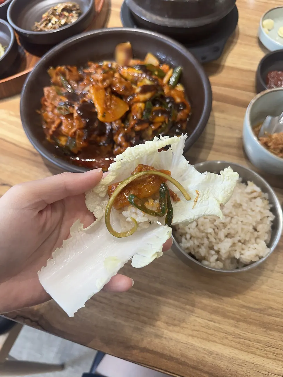 배추 위에 흑마늘밥과 제육을 올린 쌈