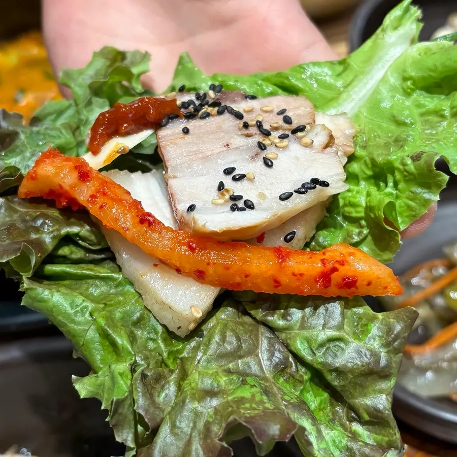 A wrap made with boiled pork and fresh greens