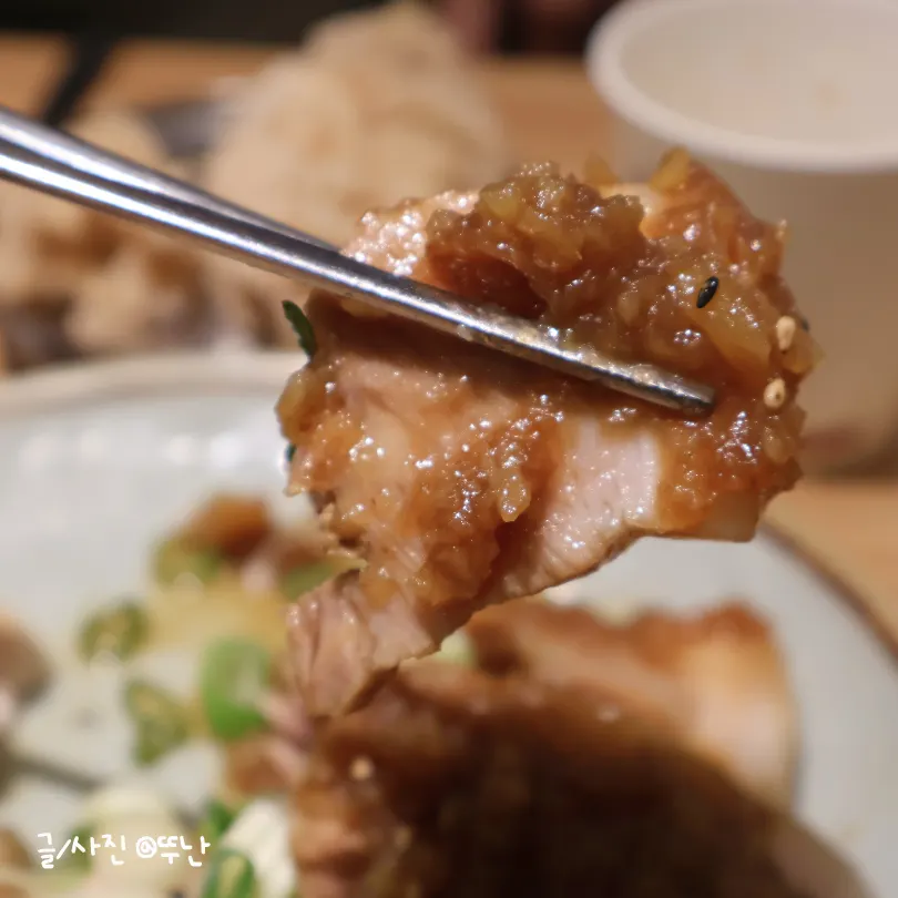 A generous mound of special black garlic sauce over the pork