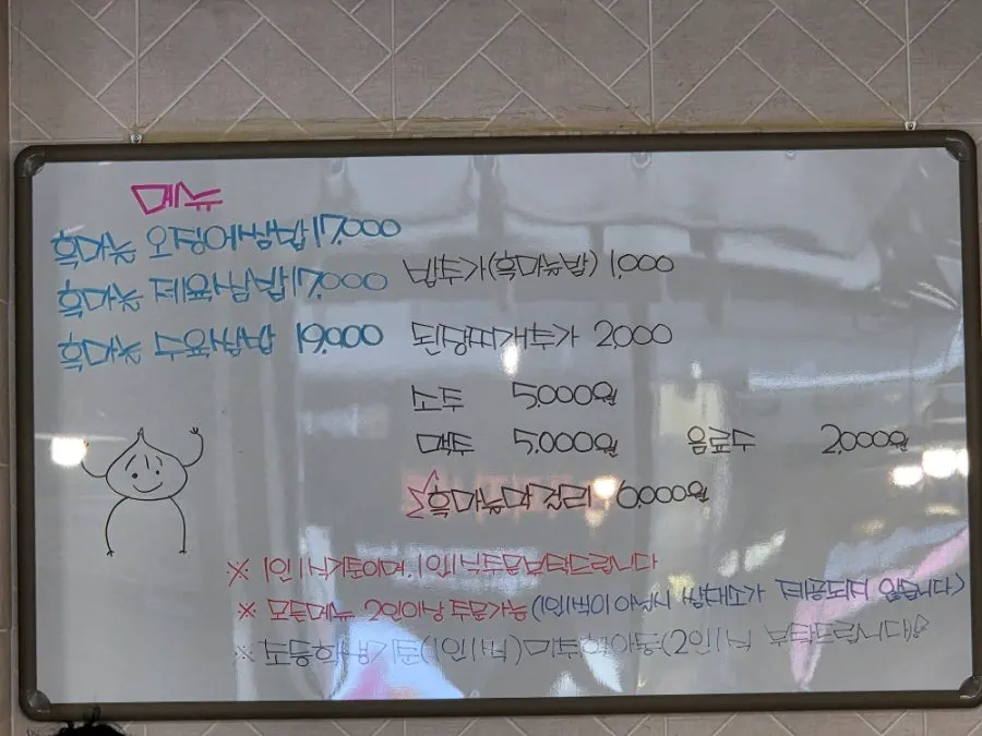 마늘 캐릭터가 그려진 단양흑마늘쌈밥 메뉴판