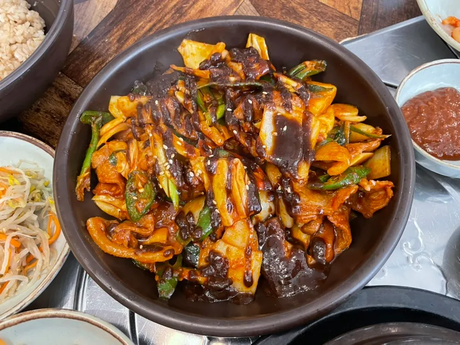A plate of jeyuk topped with black garlic sauce