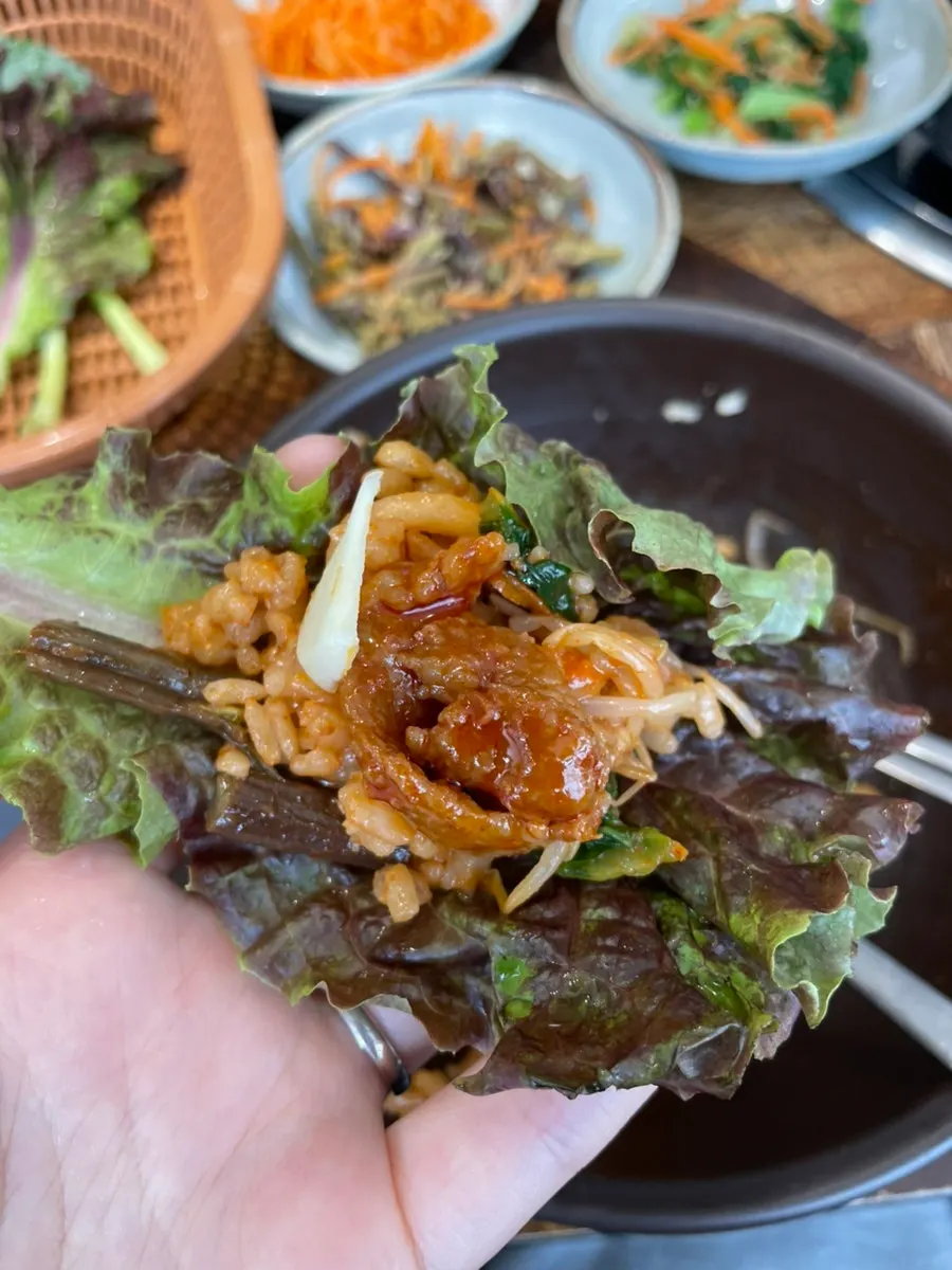 Eating the black garlic jeyuk wrapped in lettuce