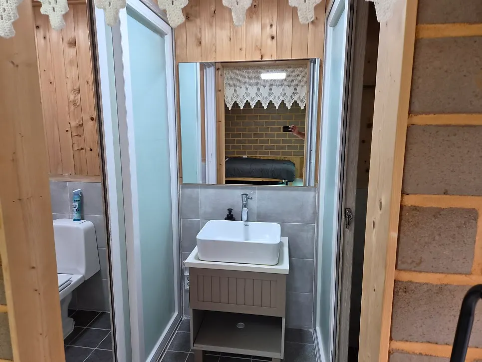 Separated bathroom and shower room around a central sink