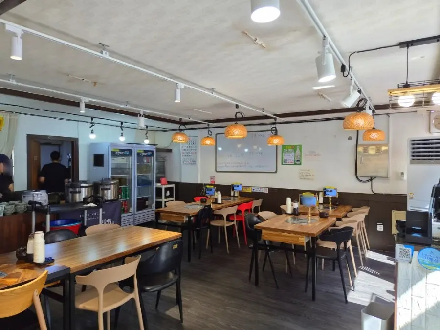 Dining hall with 4-person tables at Heukmaneul Boribap