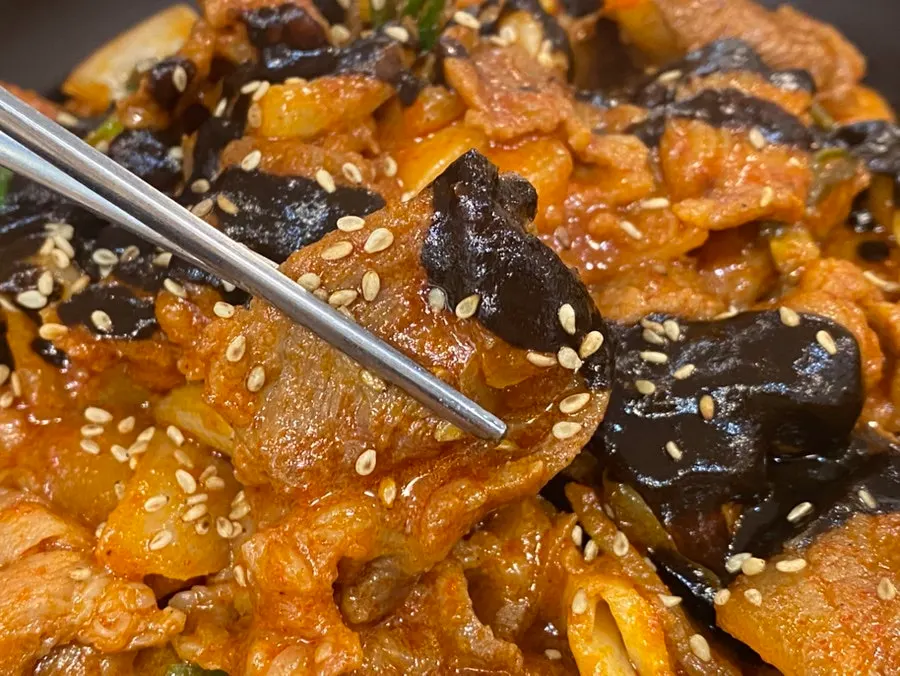 Close-up of jeyuk stir-fry topped with black black garlic sauce