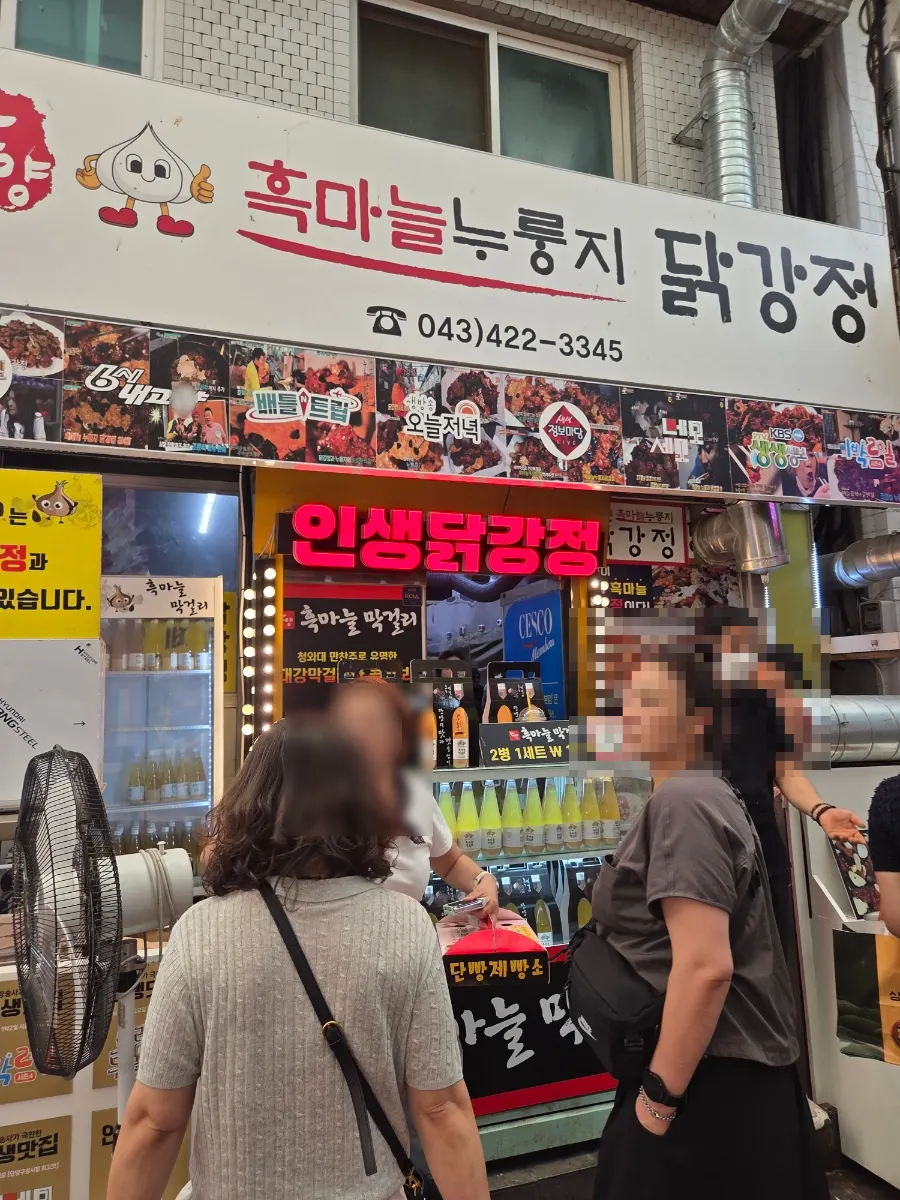 Shop sign and waiting customers at Guyeong Market dakgangjeong stall