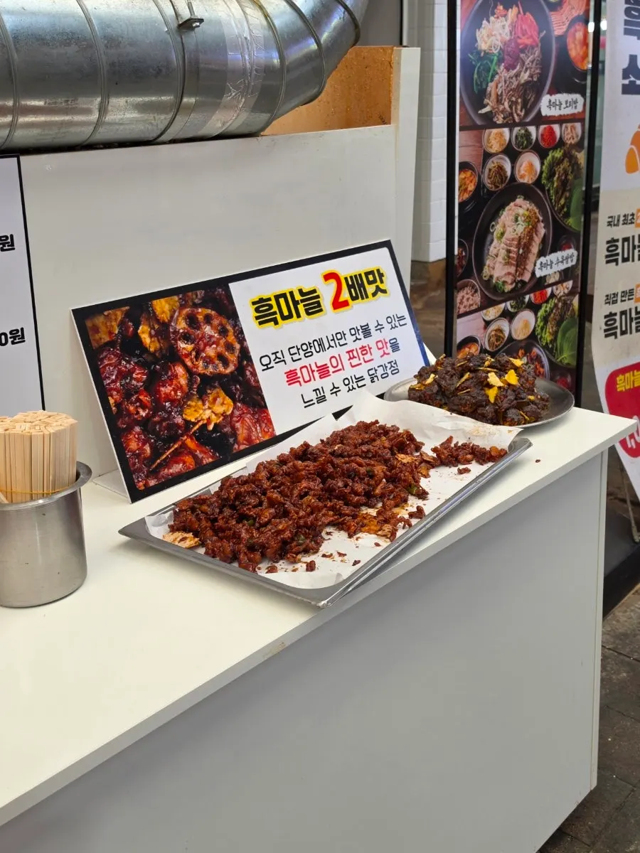 Black garlic dakgangjeong displayed on the shop counter