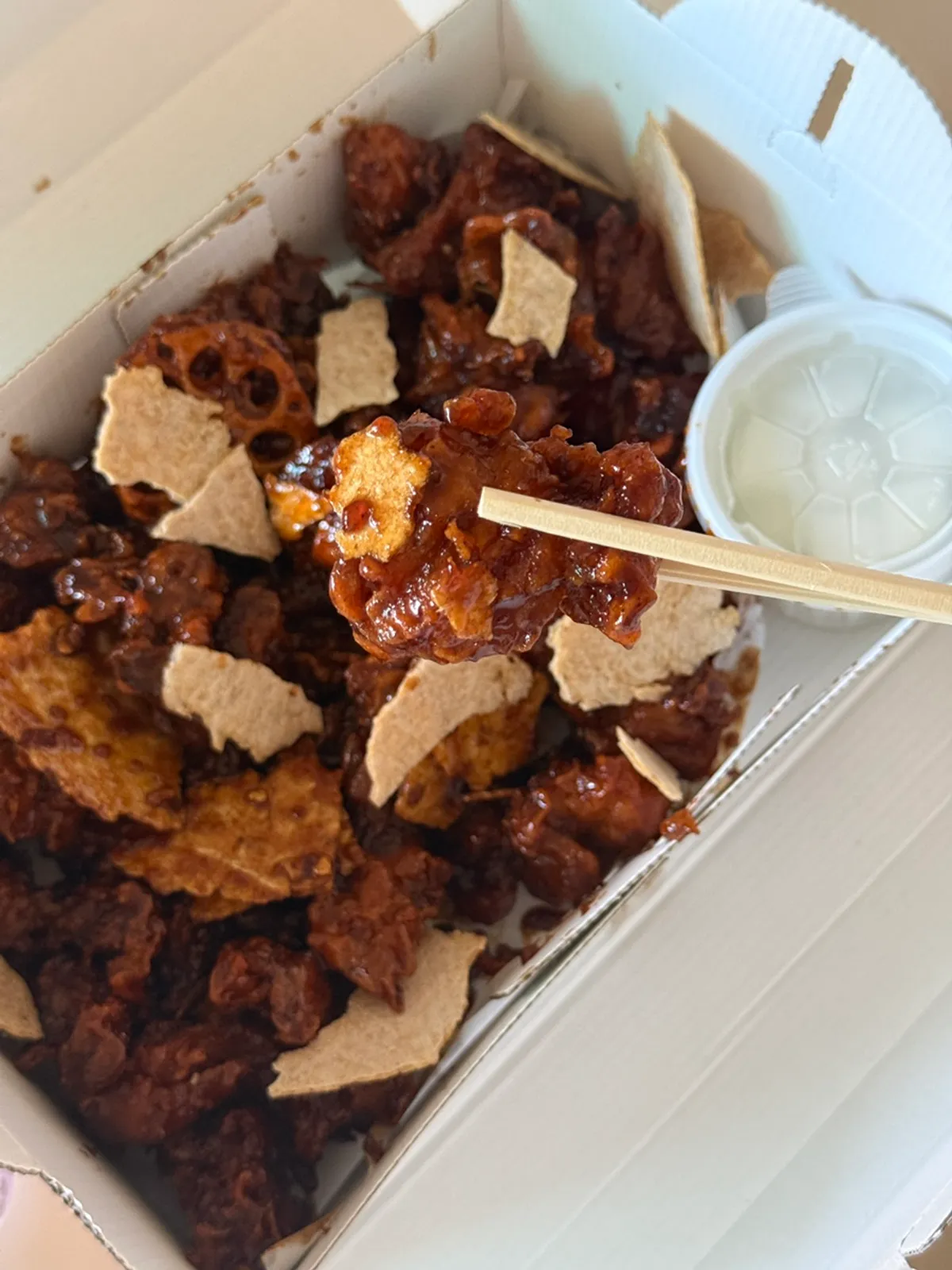 A generous box of black garlic dakgangjeong mixed with nurungji and lotus root