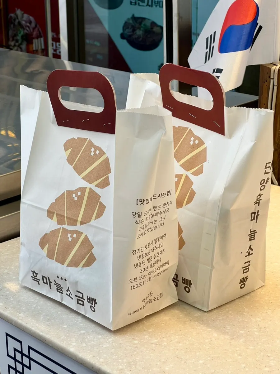 Holding the packed bag of black garlic salt bread